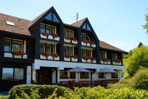 a black and white building with flowers in the windows at Landhotel Laarmann in Lennestadt