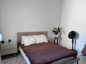 a bedroom with a bed and a white wall at Quarto deluxe in Sao Paulo