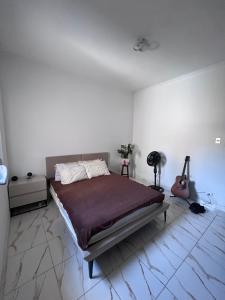 a bedroom with a bed and a guitar in it at Quarto deluxe in Sao Paulo