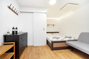 a small bedroom with a bed and a couch at Penzion Zajíček in Zaječí