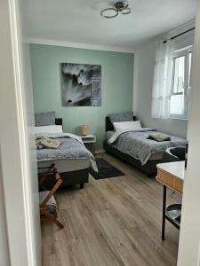 a room with two beds and a table in it at Neues Ruhrtal Apartment 3 mit Klimaanlage, Balkon in Wickede (Ruhr)