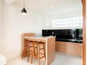 a kitchen with a island with two bar stools at Aspen bali nusa dua in Nusa Dua
