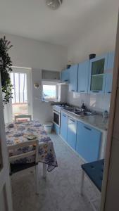 a kitchen with blue cabinets and a table in it at La casa di Nonna Rosa in Procida