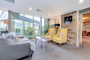 パースにあるDundee Serenity Spa Retreat near Perthの石壁のリビングルーム(黄色い椅子付)