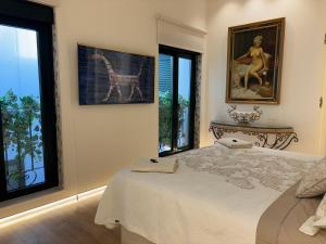 a bedroom with a bed and two large windows at El Balcón del Mercado Chico in Ávila