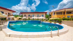 a pool at a resort with umbrellas at Souaré Club Hôtel in Dubréka