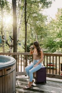 a woman sitting on a suitcase taking a picture at SkyView treehouse in Belgrade +15 photos