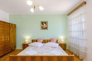 a bedroom with a bed with two lamps and a window at Holiday home in Grizane 39314 in Grižane +28 photos