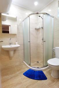 a bathroom with a shower and a toilet and a blue rug at Cabacum Pleasure Beachfront Apartments in Varna City