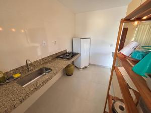 una cucina con lavello e frigorifero di Casa Tartaruga 1 - Luxo com Hidromassagem a 50m do Mar a Guriri Altre 13 foto
