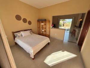 una camera da letto con un letto e un tavolo di Casa Tartaruga 1 - Luxo com Hidromassagem a 50m do Mar a Guriri