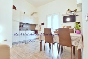 a kitchen and dining room with a table and chairs at Villa Virginia in Sarroch