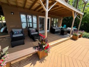 a wooden deck with chairs and furniture on a house at Red Cedar Haven Lakeside Tranquility in Sidney