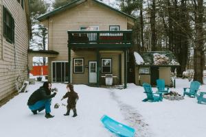 a woman and a child playing in the snow at Sunset Chalet in Belgrade