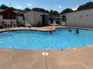 two people swimming in a swimming pool at Super 8 by Wyndham Monroe in Monroe