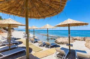 a beach with chairs and umbrellas and the ocean at Extraordinary Rethymno Villa Villa Hantengu 3 Bedrooms Beach Front Private Outdoor Swimming Pool And Hot Tub Pigianos Kampos in Pigianos Kampos