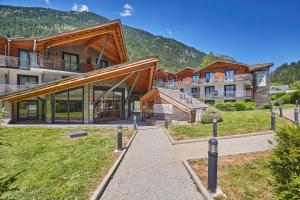 a resort with a building with mountains in the background at Résidence Odalys Isatis in Chamonix