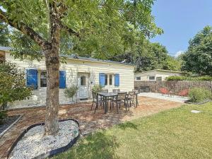 a patio with a table and chairs in front of a house at Cottage, L étrille, WIFI gratuit, proche de la mer, jardin, terrasse in Jullouville-les-Pins