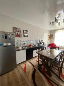 a kitchen with a table and a refrigerator at Guesthouse Luika in Oni