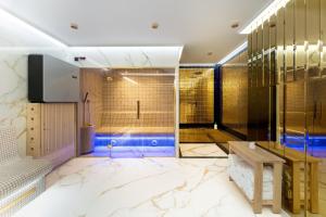 a bathroom with a walk in shower and a bench at Bulwar Residence & Wellness in Kazimierz Dolny