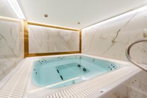 a blue bath tub in a bathroom with marble walls at Bulwar Residence & Wellness in Kazimierz Dolny