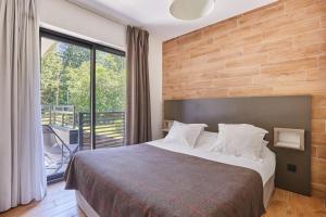 a hotel room with a bed and a balcony at Résidence Odalys Isatis in Chamonix