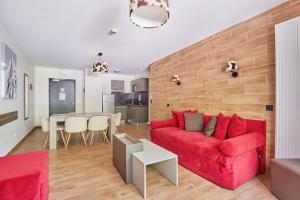 a living room with a red couch and a table at Résidence Odalys Isatis in Chamonix