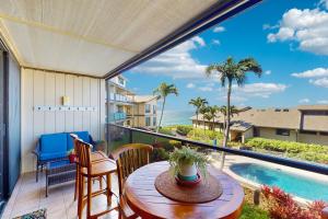 een balkon met een tafel en stoelen en een zwembad bij Making Makahuena Memories in 2204 in Koloa