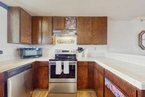 een keuken met houten kasten en een kookplaat met oven bij Making Makahuena Memories in 2204 in Koloa