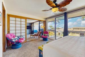 een slaapkamer met een bed en stoelen en een balkon bij Making Makahuena Memories in 2204 in Koloa +24 foto's