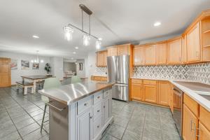 a large kitchen with wooden cabinets and a table at Lake Mary View Pickleball Paradise Penthouse Unit in Twin Lakes