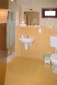 a bathroom with a sink, toilet and shower at Decsi Vendégház in Esztergom