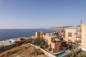 un groupe de bâtiments à côté de l'eau dans l'établissement Aeri Residence, à La Canée