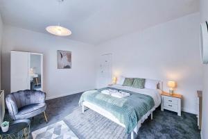 ein Schlafzimmer mit einem Bett und einem Stuhl in der Unterkunft Modern Comforts in Cleethorpes in Cleethorpes