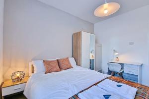 Schlafzimmer mit einem weißen Bett, einem Schreibtisch und einem Schreibtisch in der Unterkunft Modern Comforts in Cleethorpes in Cleethorpes