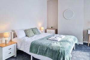 ein Schlafzimmer mit einem weißen Bett mit einer grünen Decke in der Unterkunft Modern Comforts in Cleethorpes in Cleethorpes