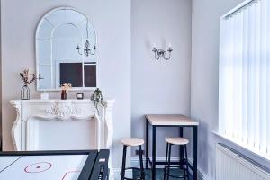 Zimmer mit einem Kamin, 2 Hockern und einem Spiegel in der Unterkunft Modern Comforts in Cleethorpes in Cleethorpes + 23 Fotos