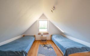 a attic room with two beds and a window at Domki u Bogdana in Dąbki