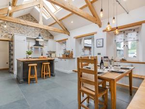 a kitchen with white cabinets and a wooden table and chairs at Cwtch Ty Gwyn in Llandeilo