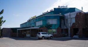 un coche blanco estacionado frente a un edificio en Гостиница "Сапсан" en Pavlodar