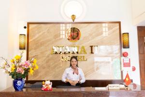 a woman is sitting on a table in a room at Atana Saigon Boutique Hotel II in Ho Chi Minh City