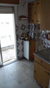 una cocina con fregadero y una ventana. en Andy's apartments, en Nea Kalikratia