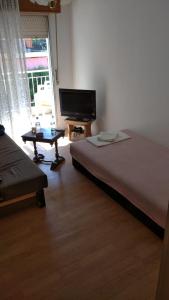 Un dormitorio con una cama, un televisor y una mesa. en Andy's apartments, en Nea Kalikratia