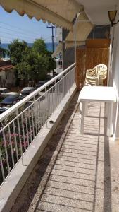 - Balcón con mesa blanca y sillas en Andy's apartments, en Nea Kalikratia