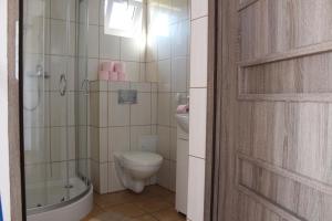 a bathroom with a toilet and a tub and a sink at Domki u Bogdana in Dąbki +14 photos