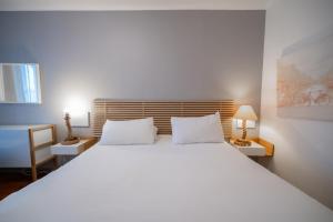 Cama ou camas em um quarto em Hotel Les Arcades