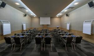 a room filled with tables and chairs with a screen at Radisson Blu Resort & Spa Cesme in Çeşme +116 photos