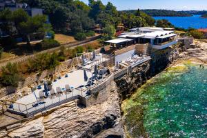 an aerial view of a house on a cliff next to the water at Arena Verudela Beach in Pula