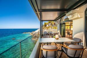 a balcony with tables and chairs and the ocean at Arena Verudela Beach in Pula