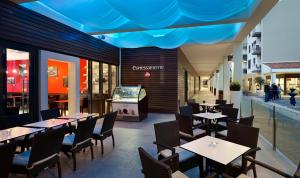 a restaurant with tables and chairs and a television at Arena Verudela Beach in Pula